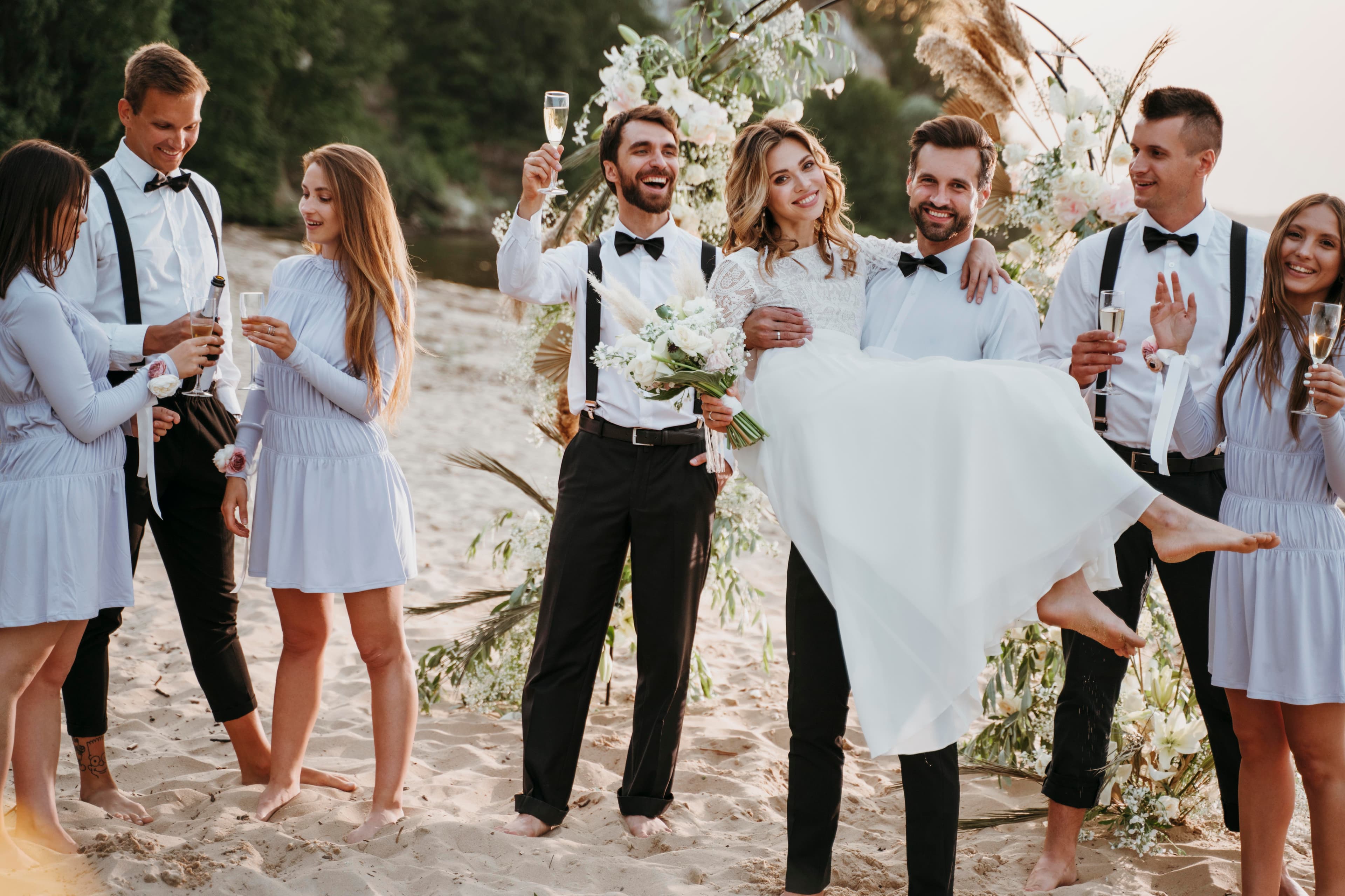 Bride and groom celebrating their wedding with guests on the beach